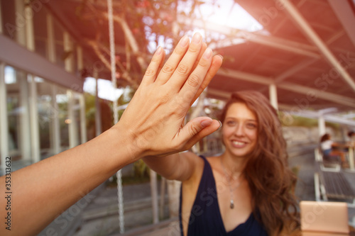 Image of friendly young people man and woman laughing and giving high five