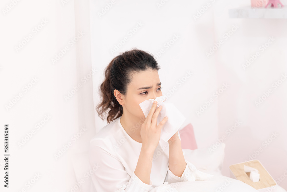 Sick woman with headache sitting under the blanket. Sick woman with seasonal infections, flu, allergy lying in bed Sick woman with headache sitting under the blanket. Sick woman with seasonal infections, flu, allergy lying in bed