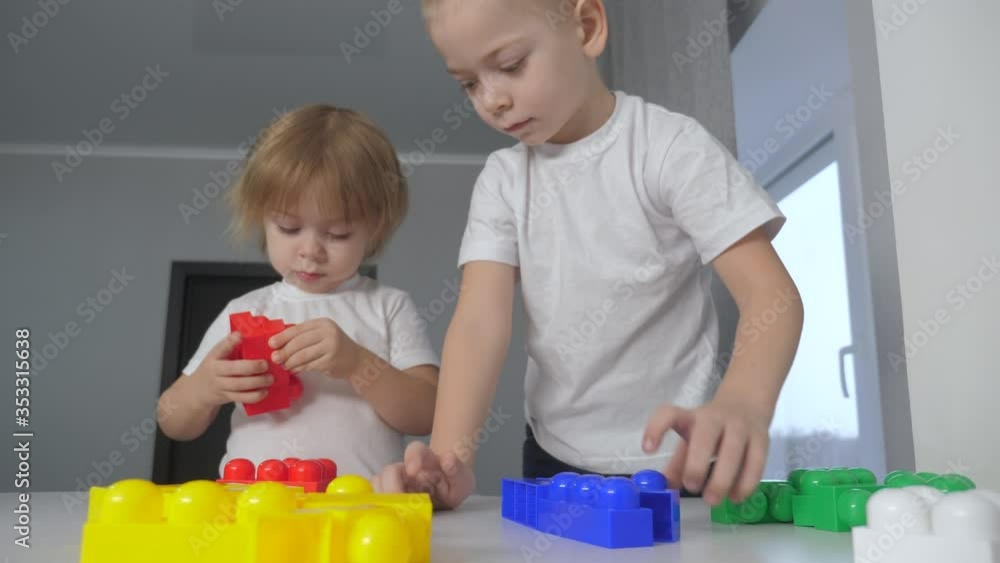 happy family boy and girl a collect constructor teamwork. kids play toys concept. children brother and sister lifestyle play indoors collect house from constructor happy family boy and girl a collect constructor teamwork. kids play toys concept. children brother and sister lifestyle play indoors collect house from constructor