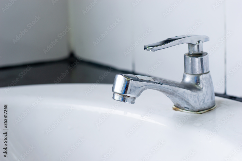 close up Sink faucet and white tle background close up Sink faucet and white tle background