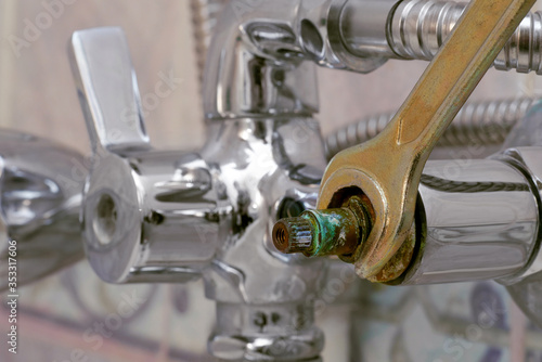 replacing defective ceramic disc cartridge covered with limescale in shower mixer using wrench