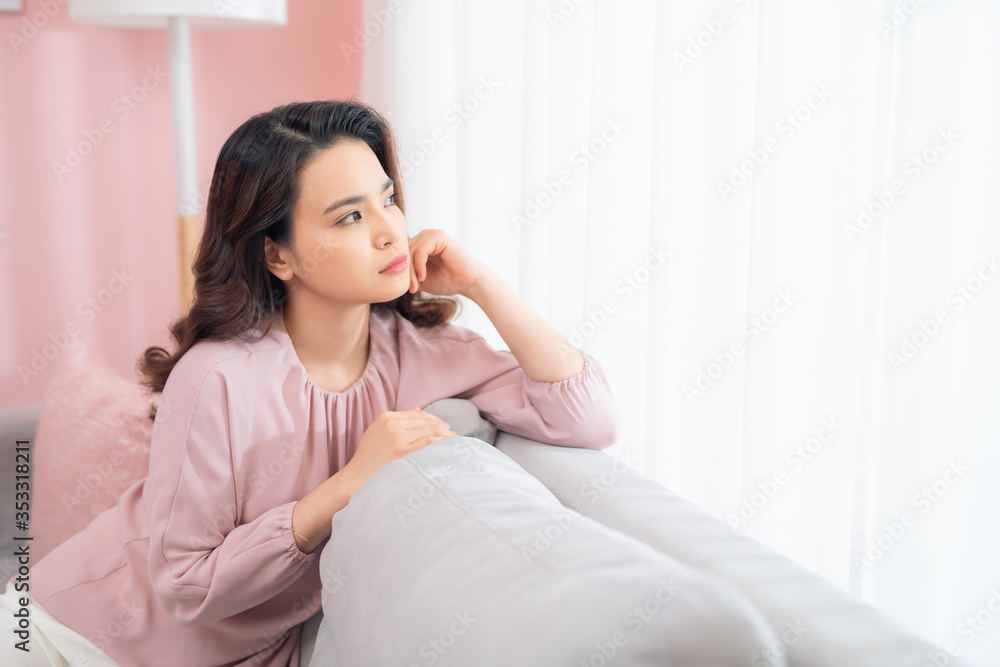 Close up young Asian woman upset when sitting at couch at home. Close up young Asian woman upset when sitting at couch at home.