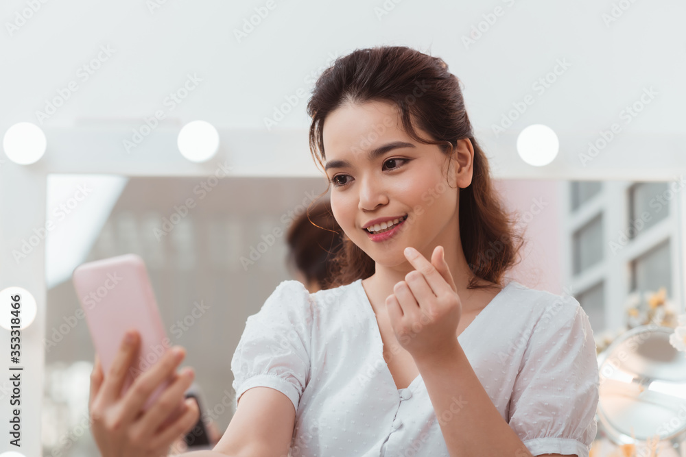 Beautiful girl with long black hair taking selfies in front of the mirror. Beautiful girl with long black hair taking selfies in front of the mirror.