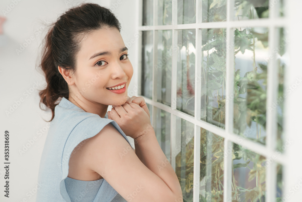 Portrait of pretty lady worker in office near window. Looking at window. Portrait of pretty lady worker in office near window. Looking at window.