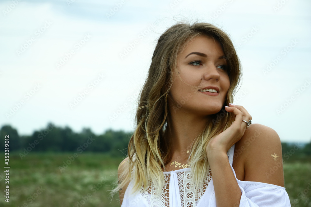 portrait of a happy flirty beautiful woman in white blouse in the field. Temporary tattoo. Drawings on body. hippie. Nature loving. portrait of a happy flirty beautiful woman in white blouse in the field. Temporary tattoo. Drawings on body. hippie. Nature loving.