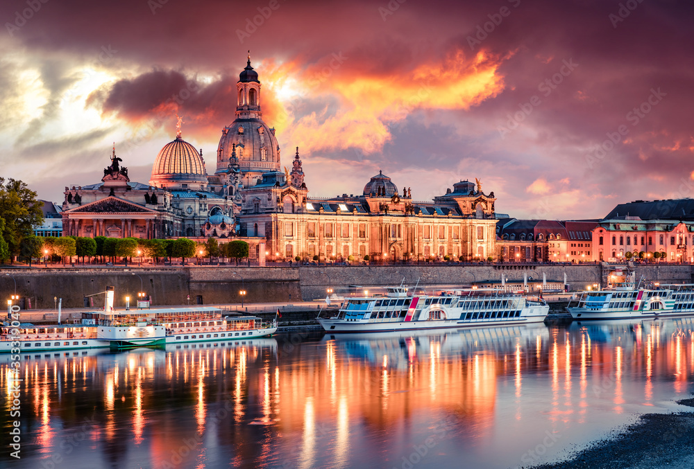 Naklejka premium Incredible spring view of Cathedral of the Holy Trinity or Hofkirche, Bruehl's Terrace or The Balcony of Europe. Colorful sunset on Elbe river in Dresden, Saxony, Germany, Europe.