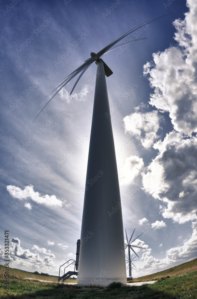 Wind turbines in field with sky and clouds Wind turbines in field with sky and clouds
