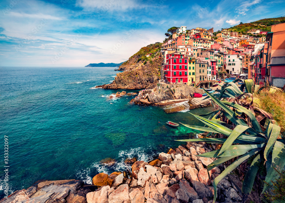 Sunny summer cityscape of Riomaggiore, first city of Cique Terre sequence of hill cities. Bright morning view of Liguria, Italy, Europe. Mediterranean seascape. Traveling concept background.