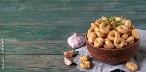 Traditional Italian snack tarallini in a ceramic bowl on a wooden green background