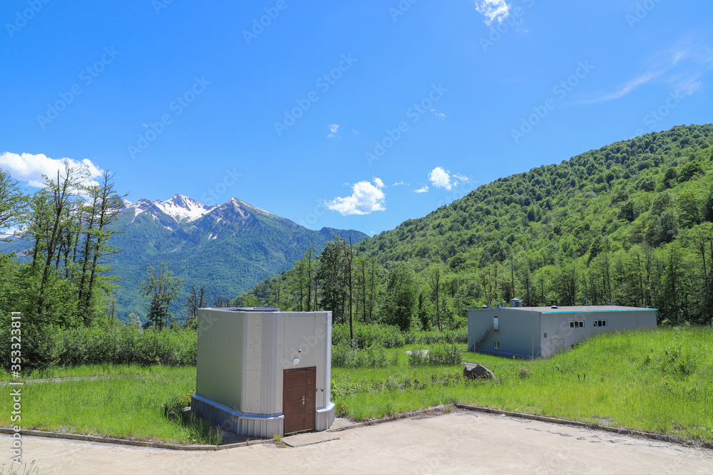 Beautiful futuristic modern water intake pumping wells against the background of mountains and snow peaks. Sochi, Russia. Beautiful futuristic modern water intake pumping wells against the background of mountains and snow peaks. Sochi, Russia.
