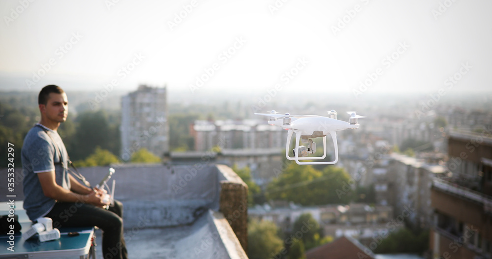 Man operating a drone with remote control on rooftop Man operating a drone with remote control on rooftop