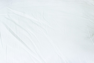 Top view of white fabric bed sheet texture background.