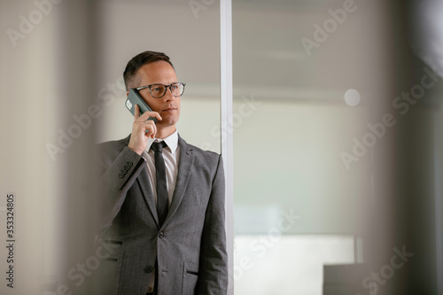 Businessman in office. Handsome man talking on phone at work.	