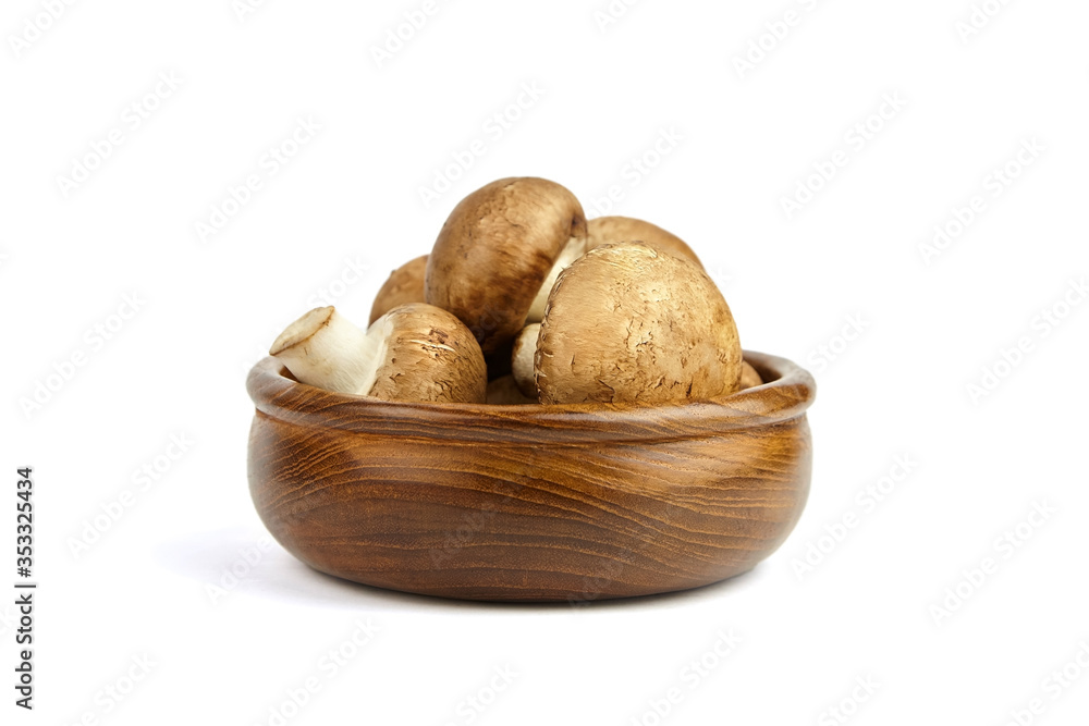 Mushrooms in wooden bowl isolated on white background. Whole fresh brown champignons Mushrooms in wooden bowl isolated on white background. Whole fresh brown champignons