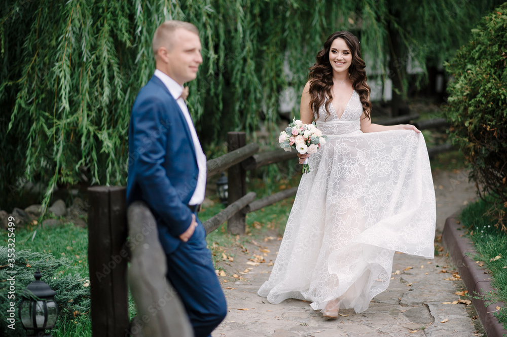 The bride holds a bouquet and her dress. A woman is looking at her husband. The bride holds a bouquet and her dress. A woman is looking at her husband.