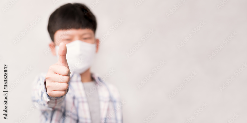 Stay safe and new normal concept, Young smart looking Asian teenage kid wear medical face mask, thumbs up and smile to support stop spreading of coronavirus and Covid-19 pandemic campaign. Stay safe and new normal concept, Young smart looking Asian teenage kid wear medical face mask, thumbs up and smile to support stop spreading of coronavirus and Covid-19 pandemic campaign.