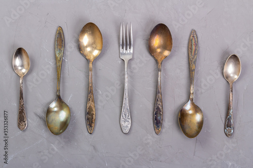 Antique cutlery laid out on a gray background