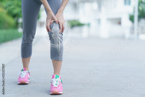 Woman holds her hands to the knee, pain in the knee, medicine, massage concept.