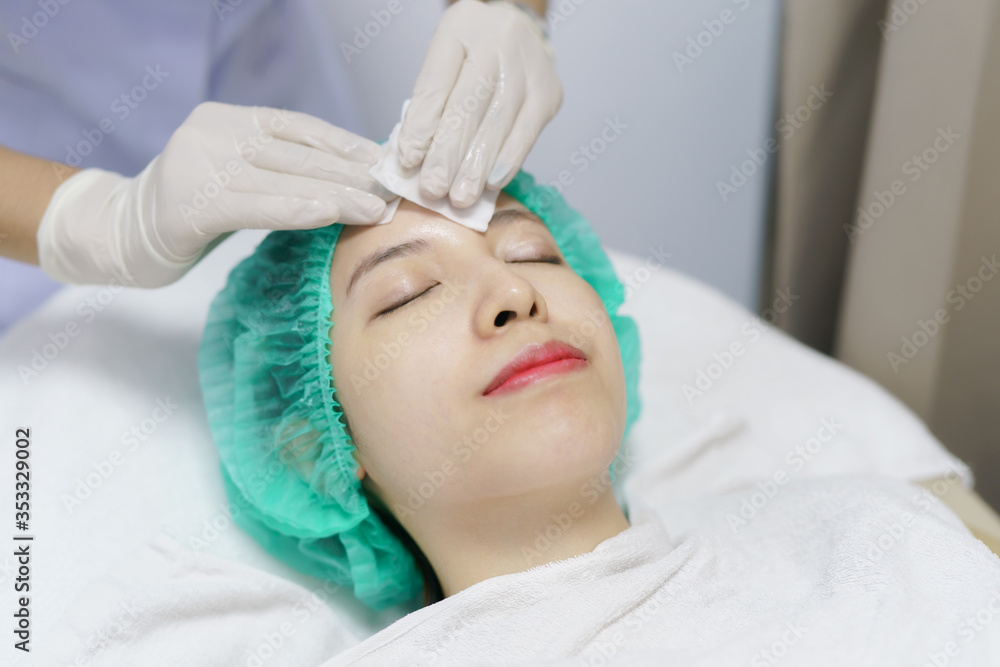 Beautician wiping woman face with cotton pads in spa. Beautician wiping woman face with cotton pads in spa.