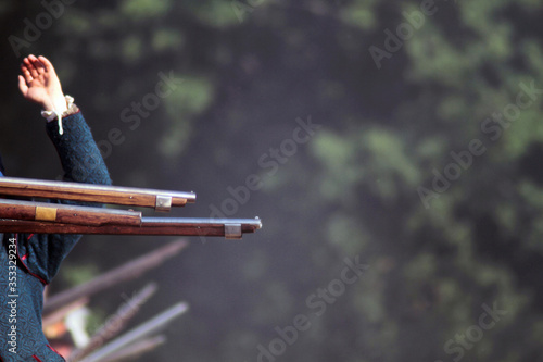 Last second before shooting down. Reenactment of battle. Musketeers with muskets or executors wait for commander's order to shoot on battlefield. Close up of ancient weapon. Execution concept. photo