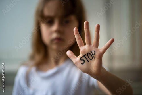 The child makes a stop gesture with his hand. Stop domestic and child abuse.