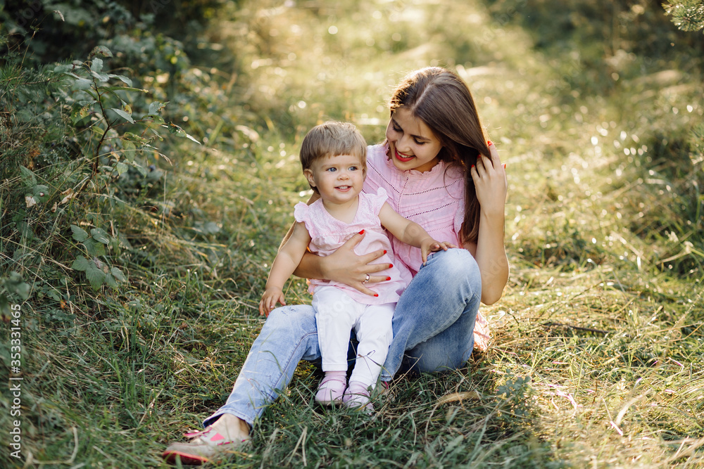 Young mother with her adorable little baby in forest Young mother with her adorable little baby in forest