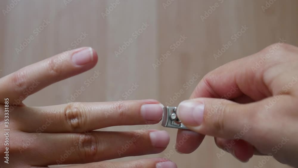Close-up of a woman using a nail clipper to cut his nails. Close-up of a woman using a nail clipper to cut his nails.