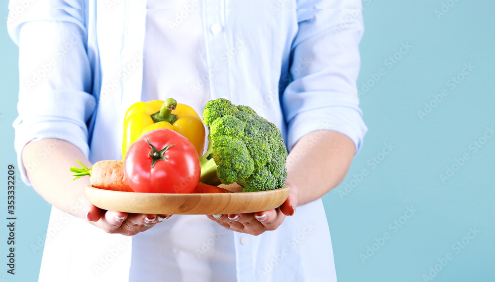 Person holding colorful vegetables empty space blue background,organic food,online market. Person holding colorful vegetables empty space blue background,organic food,online market.