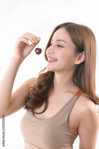 Portrait of a beautiful sexy girl on a white background, with a cherry at the lips,