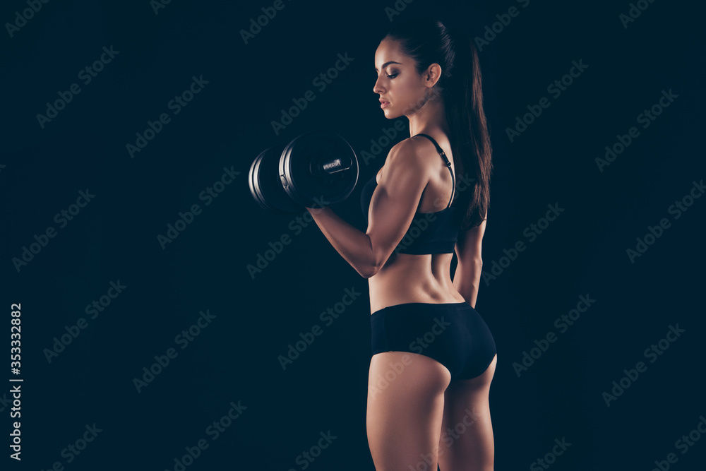 Back rear photo of charming lady youth hold hand wear tracksuit hair brunette hairstyle ponytail isolated over black background Back rear photo of charming lady youth hold hand wear tracksuit hair brunette hairstyle ponytail isolated over black background