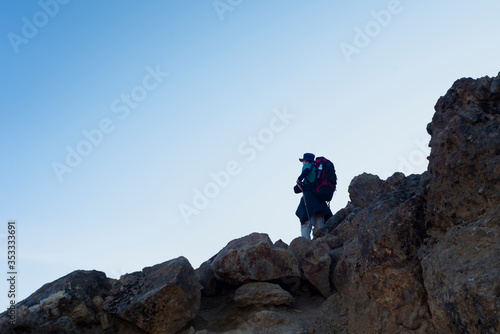 Man standing on top of rocks looking ahead on Tongariro Alpine Crossing