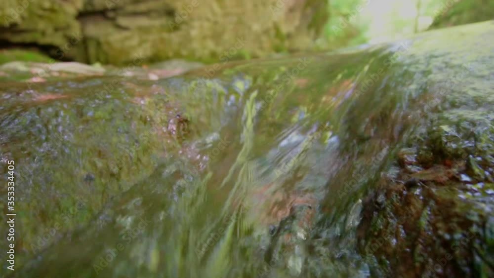 Low angle close up of flooding clear water down the stream in Switzerland Low angle close up of flooding clear water down the stream in Switzerland