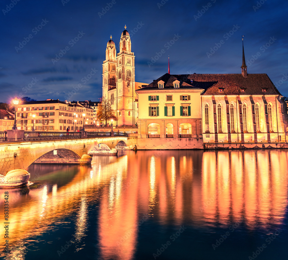 Spectacular night cityscape of Zurich city, Switzerland, Europe. Picturesque evening view of Grossmunste - Protestant church reflected in Limmat River. Traveling concept background.