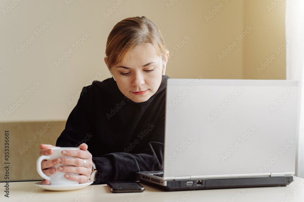 woman using laptop and mobile phone for his remote work at home