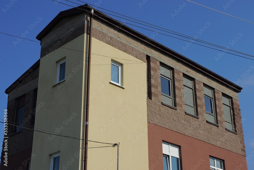 large private gray brown house with windows against a blue sky