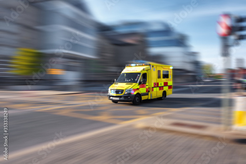 Ambulance responding to emergency call driving fast on street photo
