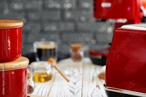 Close up photo of a red toaster on a kitchen table photo