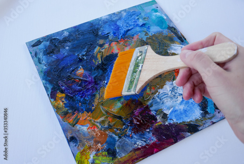 Artist, palette with paints, brushes and a palette knife on a white background.
