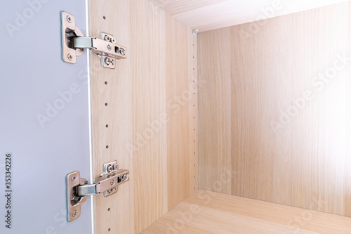 Polished Stainless door hinge on a cabinet door for interior design.