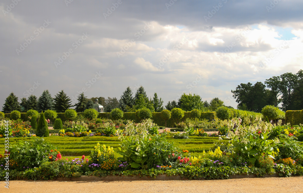 summer garden with flower beds, bushes with a gloomy stormy sky