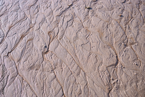 Sand erosion by tidal ranges  make line and curve on beach