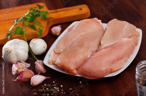 Raw chicken breast fillet with garlic and greens