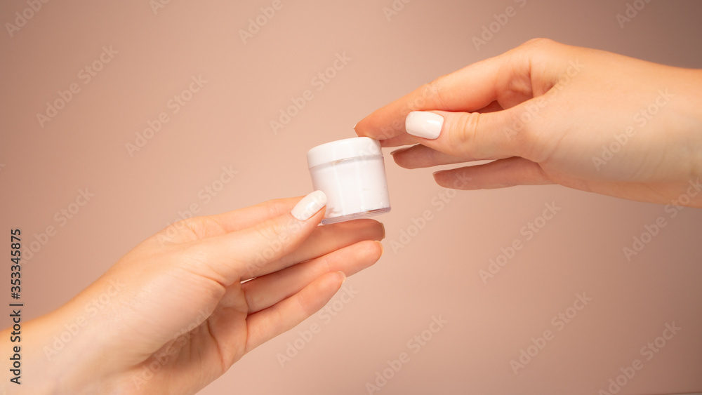 Beautiful hands hold a jar of cream. Beautiful hands hold a jar of cream.
