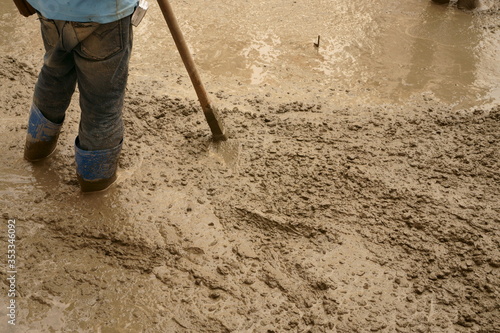A man worker plastering concrete on the floor 
