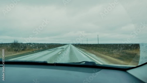 Car at high speed on rough roads in rainy weather. 
View from the cabin through the windshield.