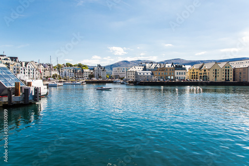 Alesund, Norway - June 2019: View of colorful Art Nouveau architecture in the port of the city of Alesund, Norway. Panoramic view of Alesunds architecture and docked sailing boats and vessels.