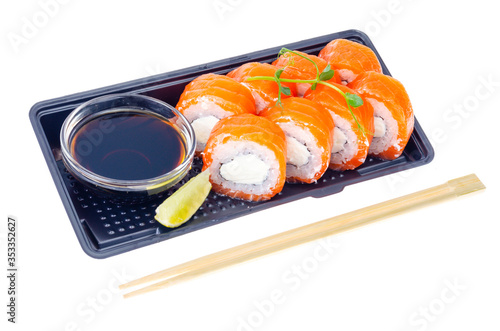 Black plate with rolls with salmon and soy sauce, Japanese cuisine
