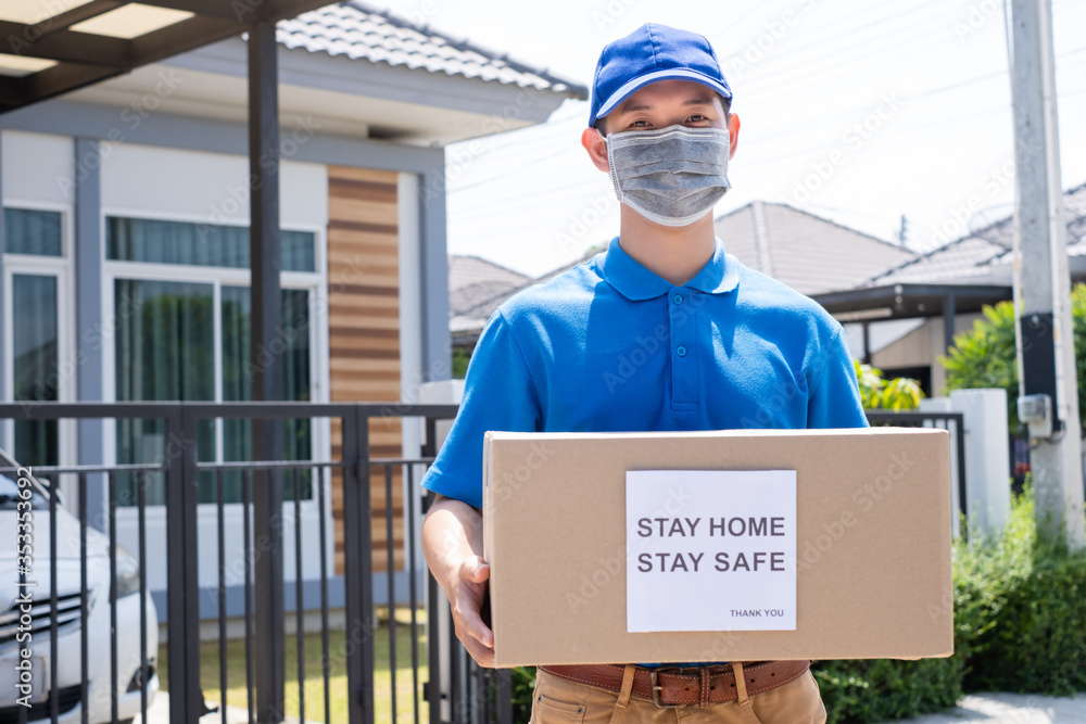 Delivery service male in uniform give cardboard box package to receiver customer client front home, fast express offsite when crisis coronavirus, covid19 new normal lifestyle concept. Delivery service male in uniform give cardboard box package to receiver customer client front home, fast express offsite when crisis coronavirus, covid19 new normal lifestyle concept.