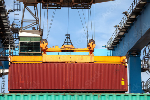 Transtainer crane moving a Shipping Container to a storage platform.
 photo