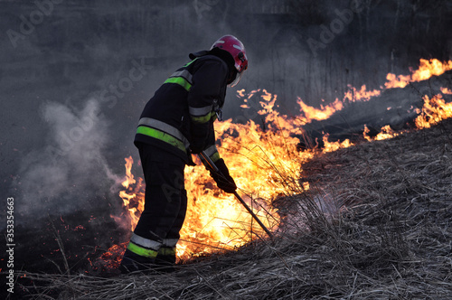 Firefighters blow out a fire in in the meadow